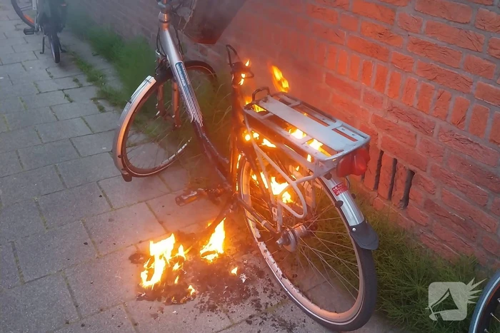 Fiets in brand tegen gevel van woning
