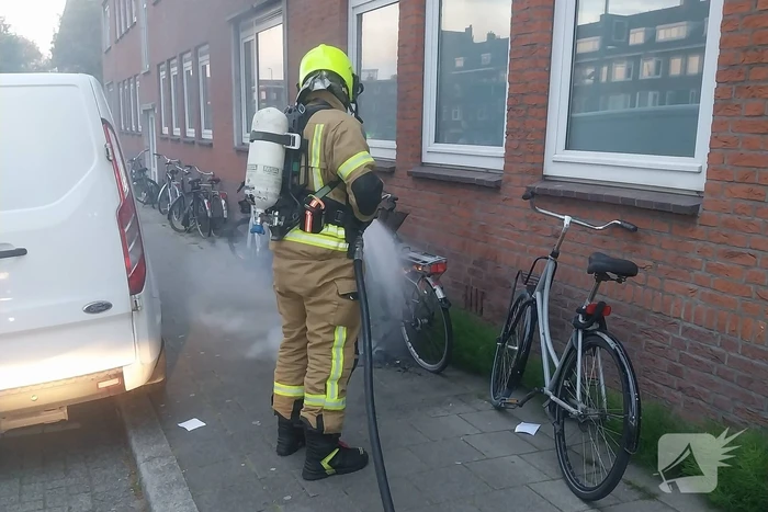 Fiets in brand tegen gevel van woning