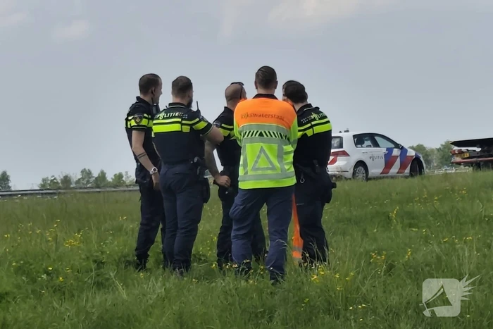 Auto belandt op zijkant in sloot naast snelweg
