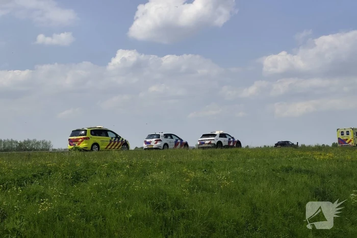Auto belandt op zijkant in sloot naast snelweg