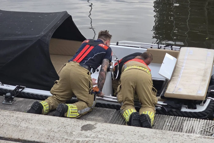 Brandweer haalt boot naar kade na brand