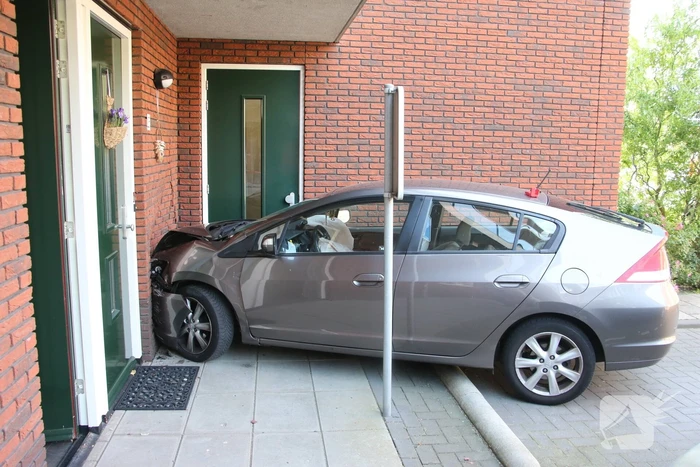 Automobilist ramt muur van appartementencomplex