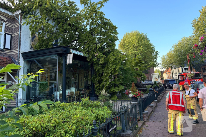 Grote boom valt op terras van cafe