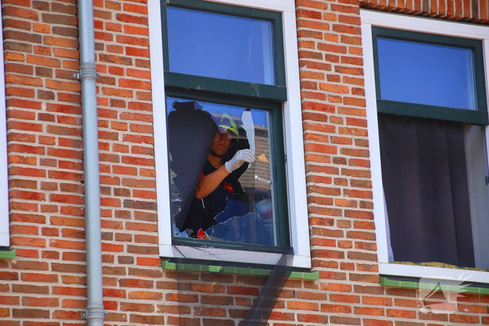 Verrotte boom valt op auto en tegen woning