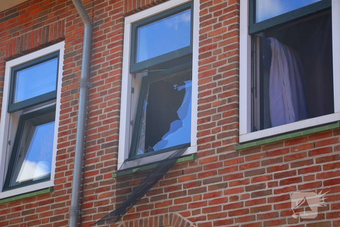 Verrotte boom valt op auto en tegen woning