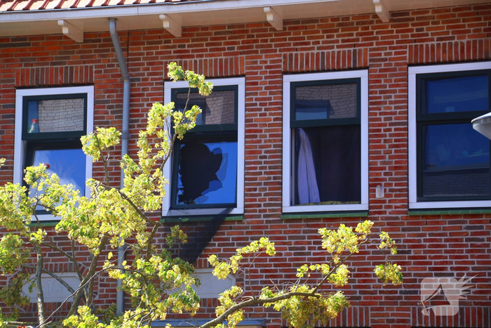Verrotte boom valt op auto en tegen woning