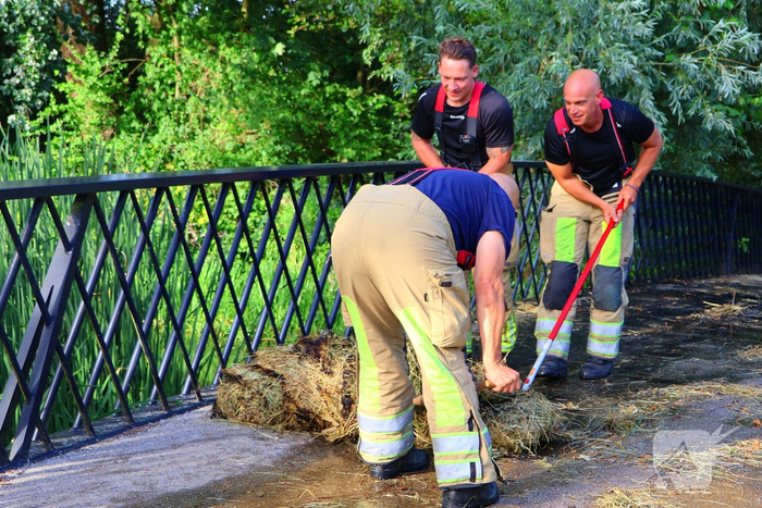 Brandweer blust brandende hooibaal