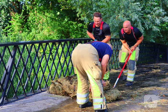 Brandweer blust brandende hooibaal