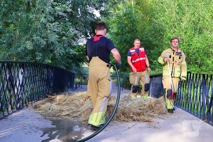 Brandweer blust brandende hooibaal