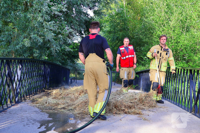 Brandweer blust brandende hooibaal