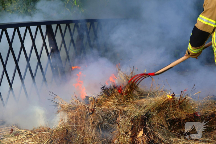 Brandweer blust brandende hooibaal