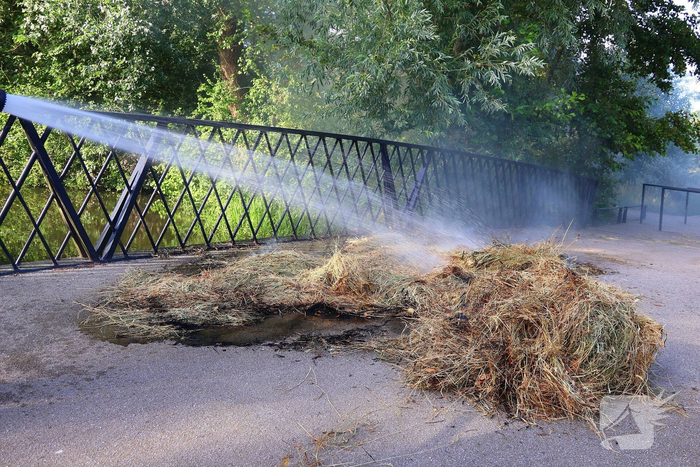 Brandweer blust brandende hooibaal