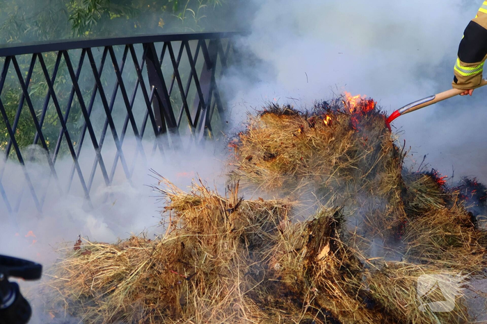 Brandweer blust brandende hooibaal