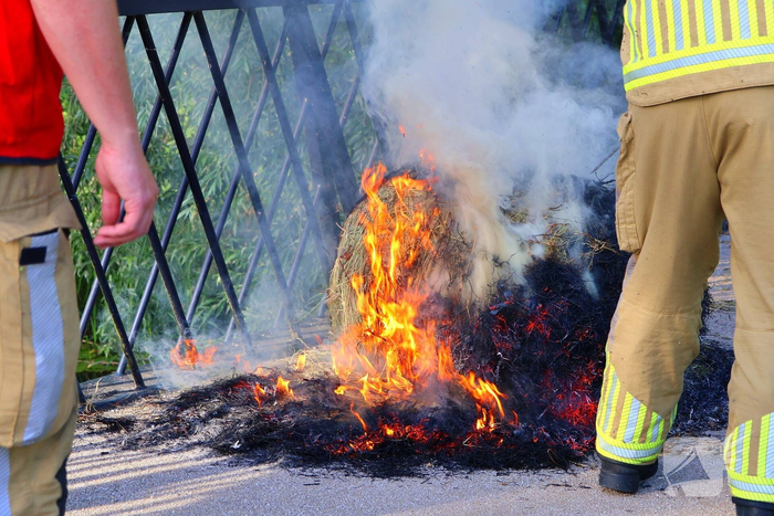 Brandweer blust brandende hooibaal