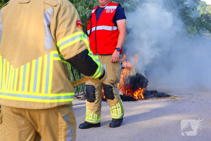 Brandweer blust brandende hooibaal