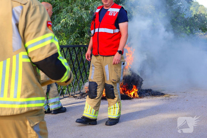 Brandweer blust brandende hooibaal
