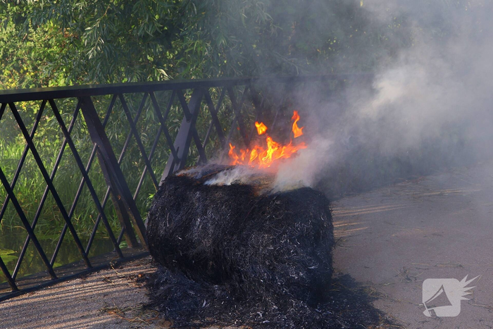 Brandweer blust brandende hooibaal