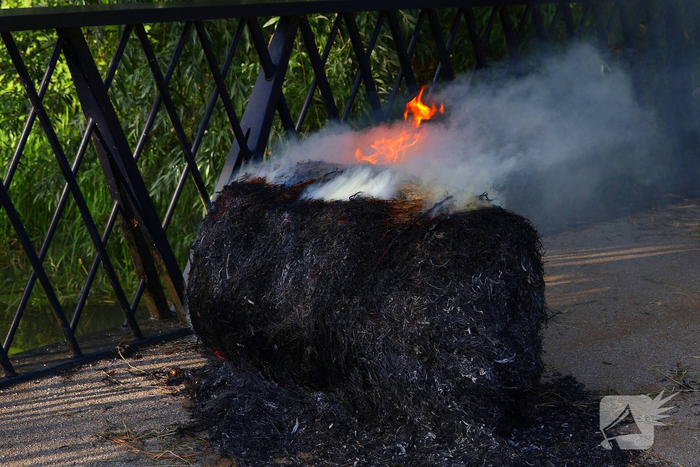 Brandweer blust brandende hooibaal