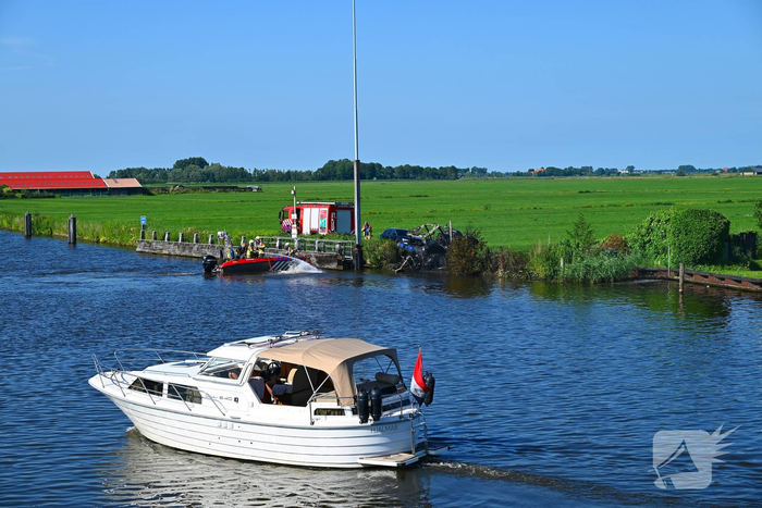 Tractor brandt uit langs waterkant, blusboot ingezet