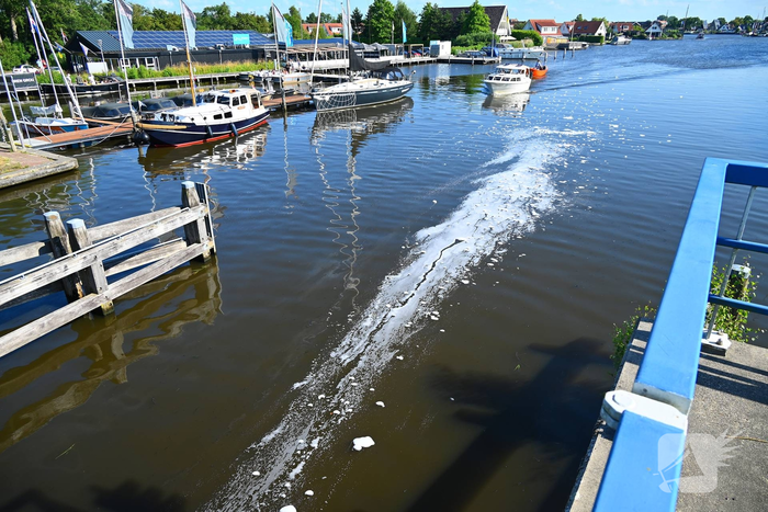 Tractor brandt uit langs waterkant, blusboot ingezet