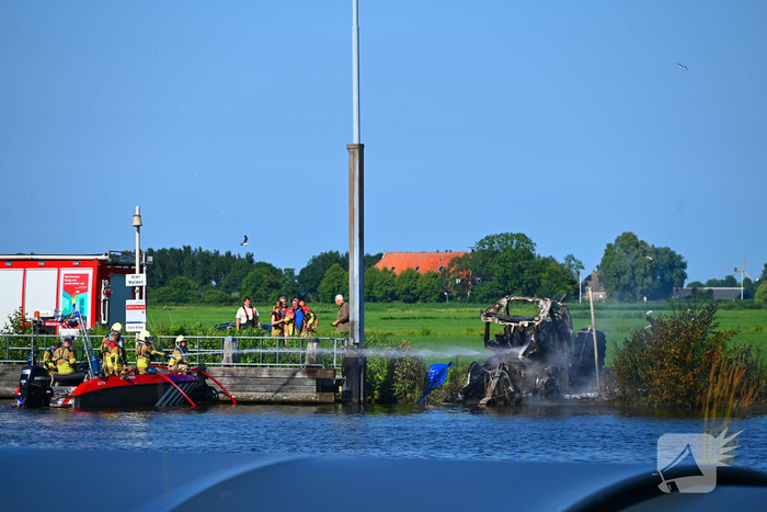 Tractor brandt uit langs waterkant, blusboot ingezet