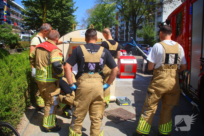 Brandweer haalt portemonnee uit kledingbak