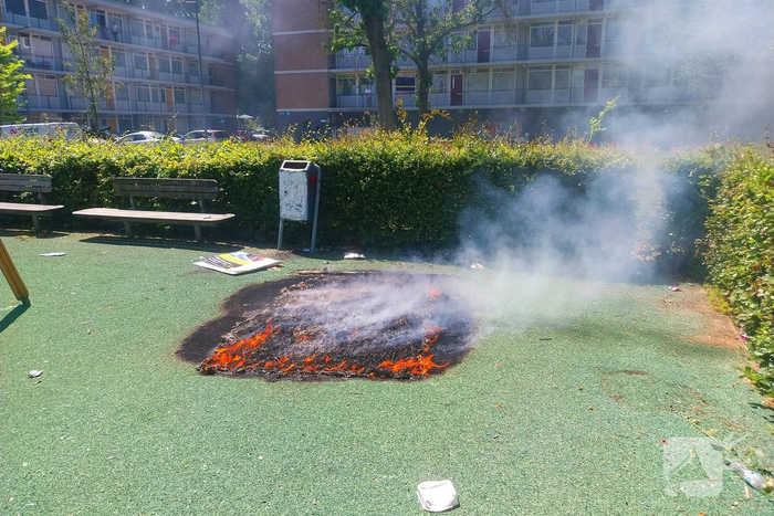 Brandend kunstgras geblust door brandweer