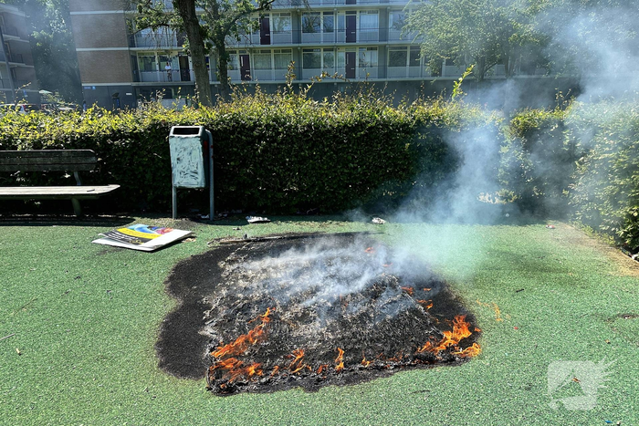 Brandend kunstgras geblust door brandweer
