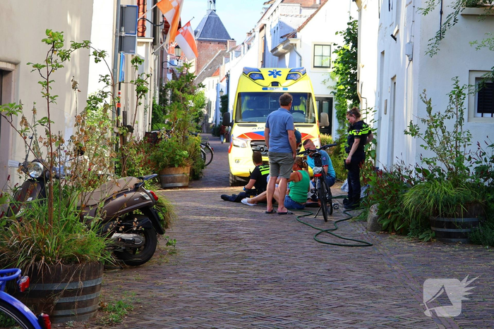 Oudere man valt van fiets