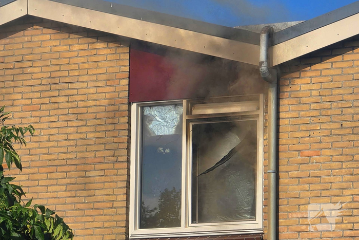 Rookwolken uit woning bij brand