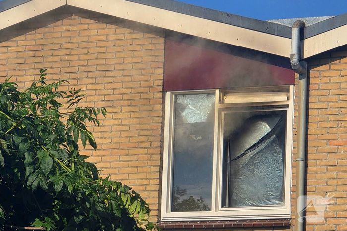 Rookwolken uit woning bij brand