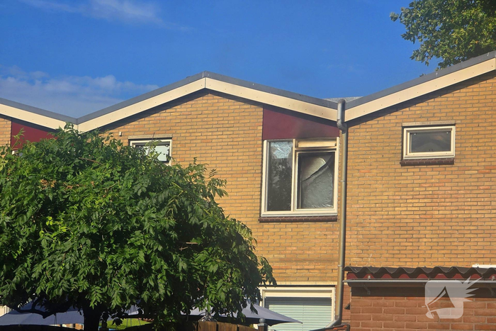 Rookwolken uit woning bij brand