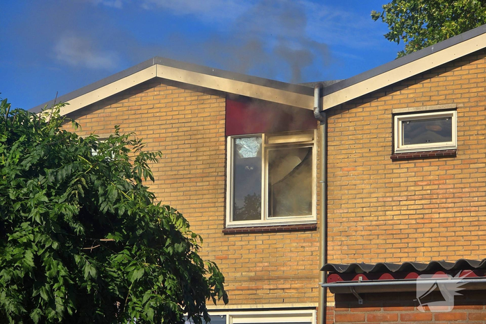 Rookwolken uit woning bij brand
