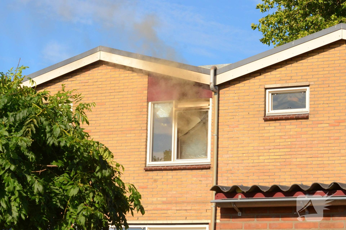 Rookwolken uit woning bij brand