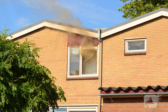 Rookwolken uit woning bij brand