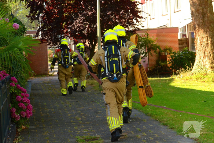 Rookwolken uit woning bij brand