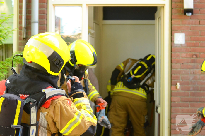 Rookwolken uit woning bij brand