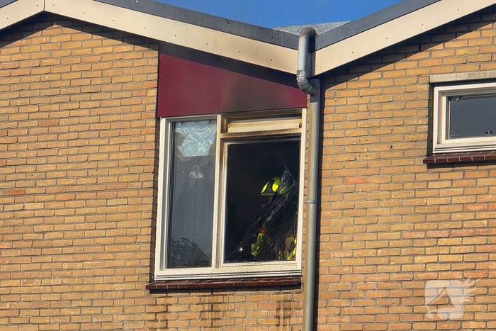 Rookwolken uit woning bij brand