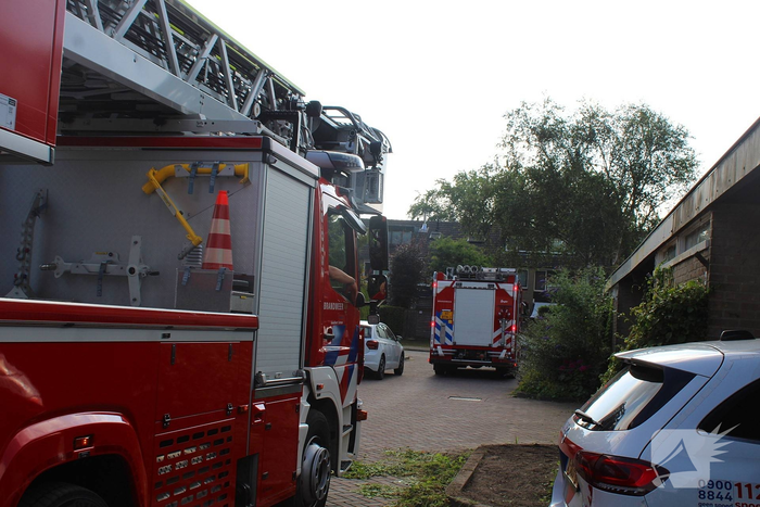 Brandweer inspecteert dak na melding brandlucht