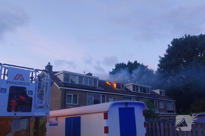 Dakkapel in vlammen, brandweer schaalt op