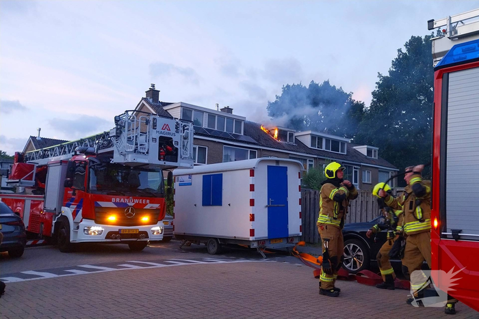 Dakkapel in vlammen, brandweer schaalt op