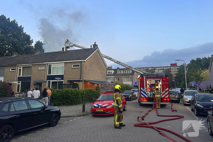 Dakkapel in vlammen, brandweer schaalt op