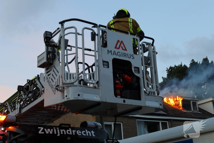 Dakkapel in vlammen, brandweer schaalt op