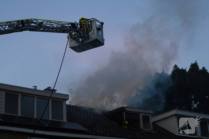 Dakkapel in vlammen, brandweer schaalt op
