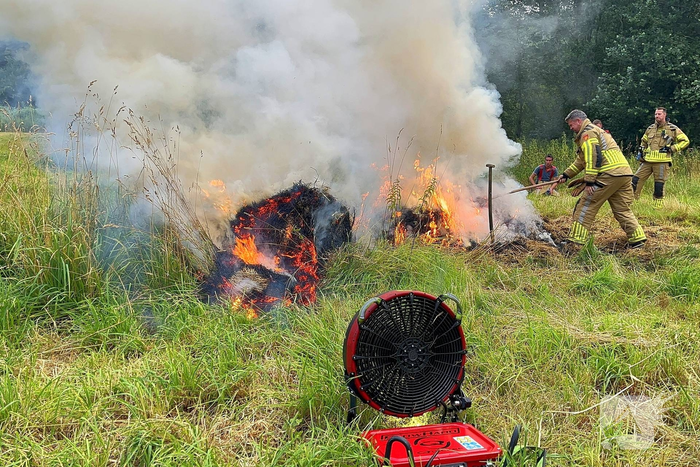 Brandweer blust brand in hooibaal