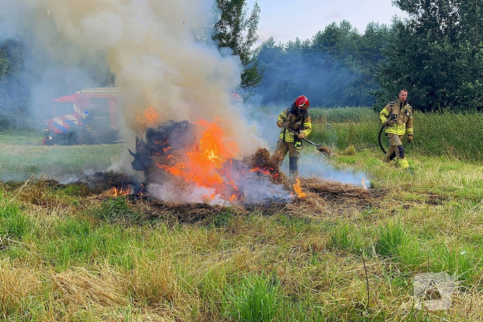 Brandweer blust brand in hooibaal