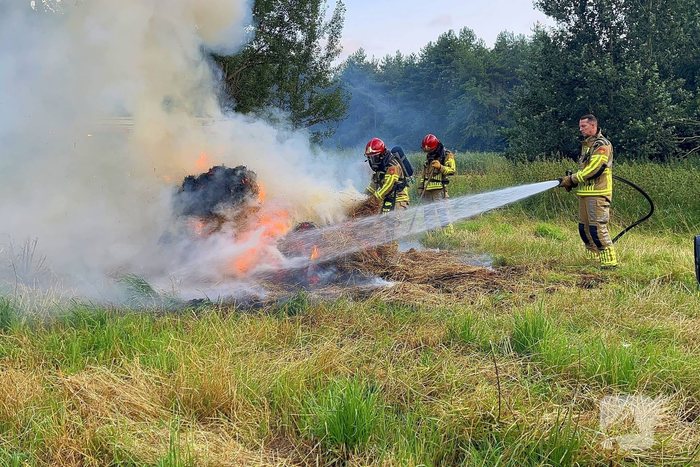 Brandweer blust brand in hooibaal