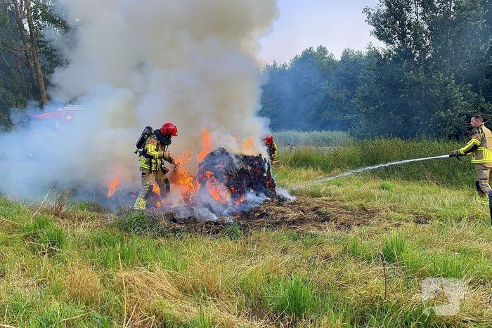 Brandweer blust brand in hooibaal