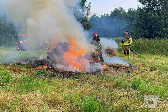 Brandweer blust brand in hooibaal