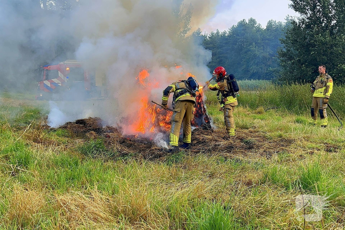 Brandweer blust brand in hooibaal